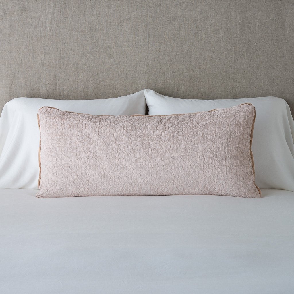 Pearl: Vienna 16x36 pillow leaning upright against white sleeping pillows on a neutral headboard - pearl.