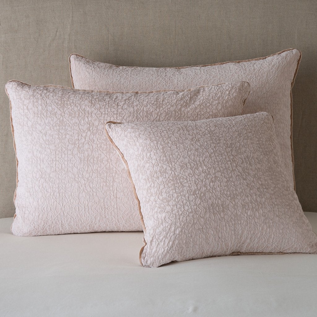 Pearl: Cotton chenille jacquard shams leaning upright against a neutral headboard.