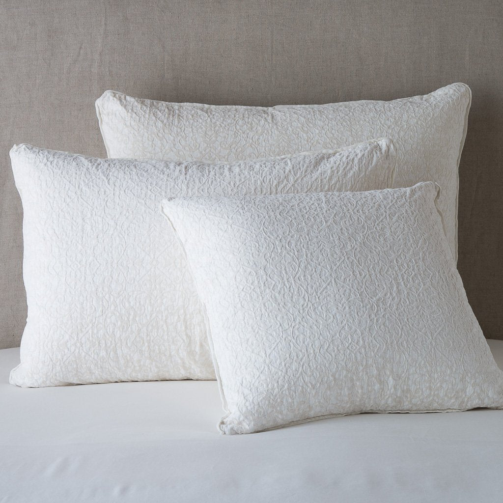 Winter White: Cotton chenille jacquard shams leaning upright against a neutral headboard.